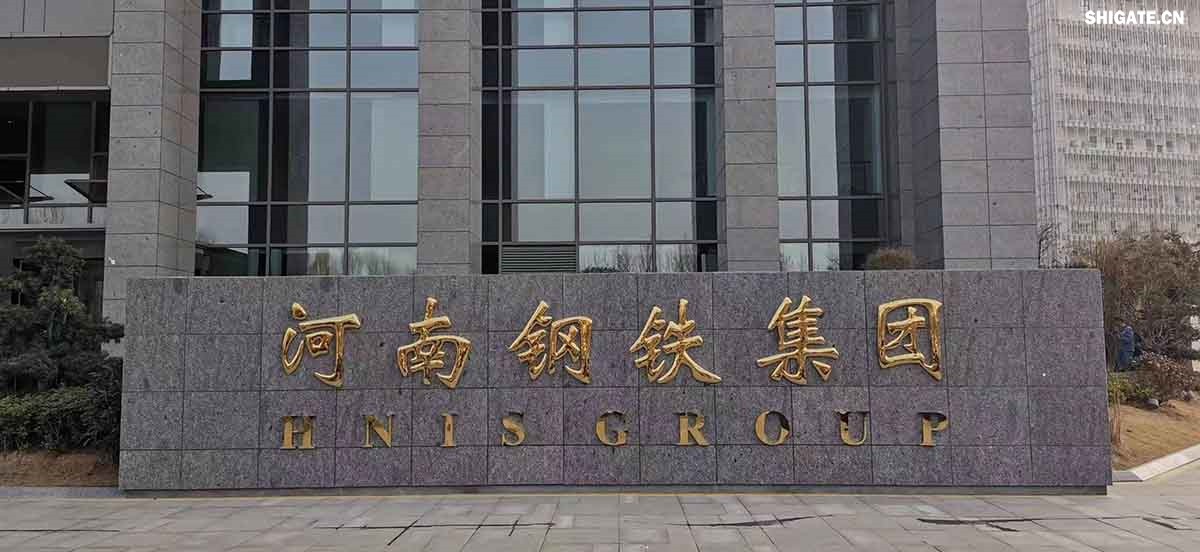 6月1日，河南鋼鐵集團(tuán)周口基地簡稱（周鋼）二期寬厚板項目控制中心迎來重要里程碑：當(dāng)操作員按下5500mm精軋機(jī)的軋制按鈕，通紅的鋼板如熔金般奔騰穿過軋輥，標(biāo)志著5500mm軋機(jī)熱試圓滿成功。這一震撼場景與5月31日RH真空精煉爐、熱處理線熱試成功交相輝映，正式宣告世界首條“5600mm+5500mm雙超寬機(jī)架”寬厚板生產(chǎn)線全線貫通！生產(chǎn)線總長度達(dá)到1.4公里，構(gòu)成了國內(nèi)已知更長的寬厚板軋鋼車間，連接了近20個精密工序，深基坑群實現(xiàn)了全線的貫通布局。至此，河南鋼鐵集團(tuán)強(qiáng)勢躋身全球鋼鐵制造“一梯隊”，其智能化、綠色化發(fā)展及特鋼轉(zhuǎn)型進(jìn)程由此開啟全新篇章！